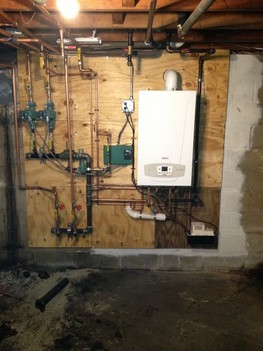  We upgraded John's old inefficient setup by converting him to natural gas and installing a premium high-efficiency combination boiler/hot water heater from Baxi, neatly hung on his basement wall. This has the added benefit of dramatically increasing his usable floor space by removing the oil tank, boiler, and water heater. Not to mention the savings in his utility bill every month!
